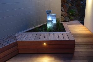 Landscaping: Raised planter box with a water feature inside surrounded by decking